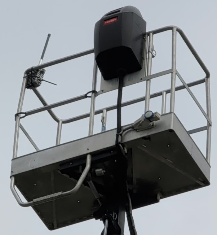 La cesta della piattaforma aerea vista da sotto, con il gateway EnjoyBuds e la sua antenna fissati al parapetto